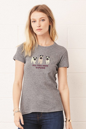 Woman in a grey t-shirt  with 3 pug dogs on the front and the words “All you need is pugs” written underneath in black.