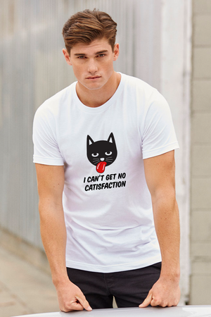 White T-shirt with a black cat face sticking its tongue out. Underneath it are the words I Can’t Get No CATISFACTION written in black.  